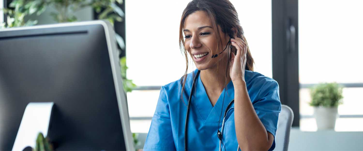 A CorVel Nurse Case Manager talking with earphone while explaining medical treatment to patient through a video call with computer in the consultation.